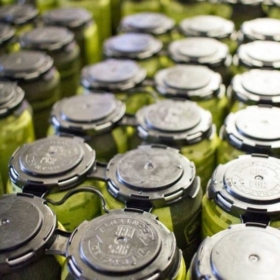 A large group of green jars sitting on top of each other.