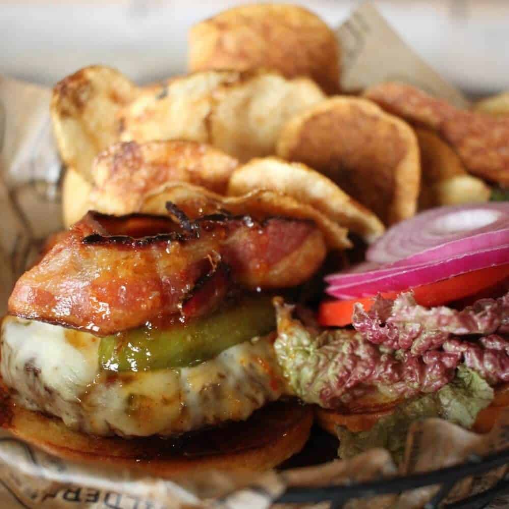 A hamburger with pickles and onions on top of it.