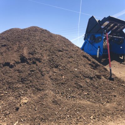 A pile of dirt next to a blue truck.